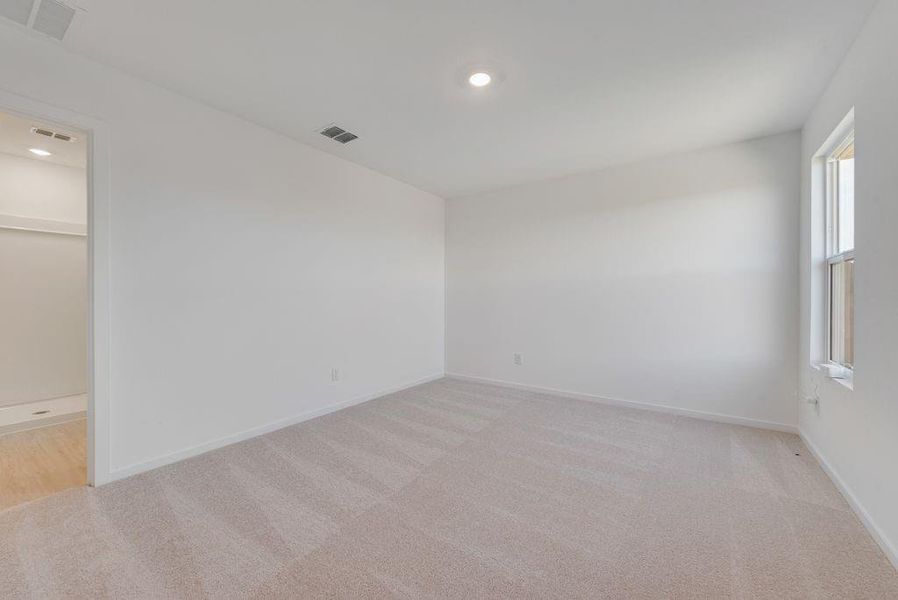 Spare room featuring light colored carpet and recessed lighting