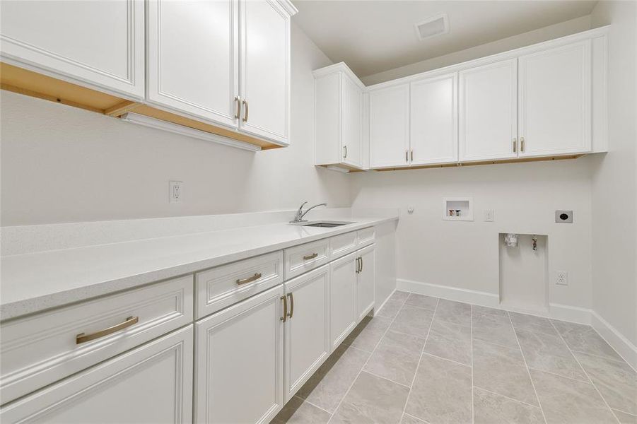 The utility room is loaded with cabinets and a sink!