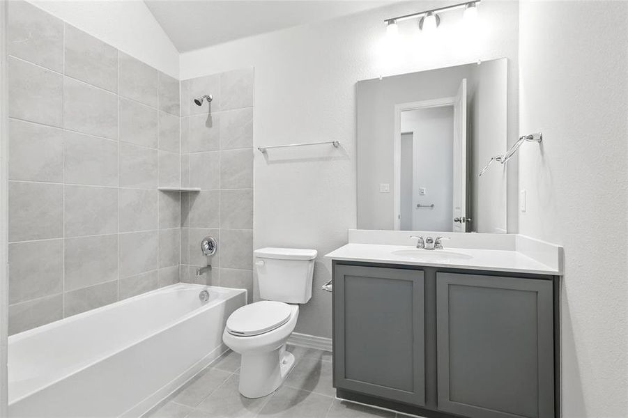 Bathroom with vanity, bathtub / shower combination, and light tile patterned flooring