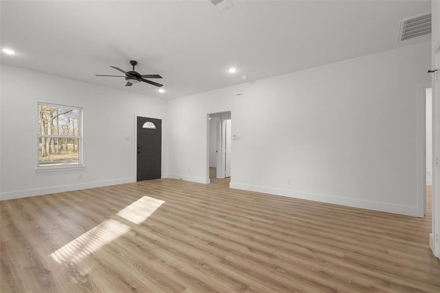 Unfurnished living room featuring ceiling fan and light hardwood / wood-style flooring