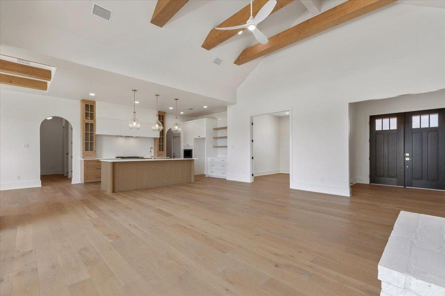 From the double-door entry, the home opens into a large great room with vaulted ceilings, warm wood beams and an open-concept kitchen. Wood flooring flows throughout the house. From the double-door entry, the home opens into a large great room with vaulted ceilings, warm wood beams and an open-concept kitchen. Wood flooring flows throughout the house.