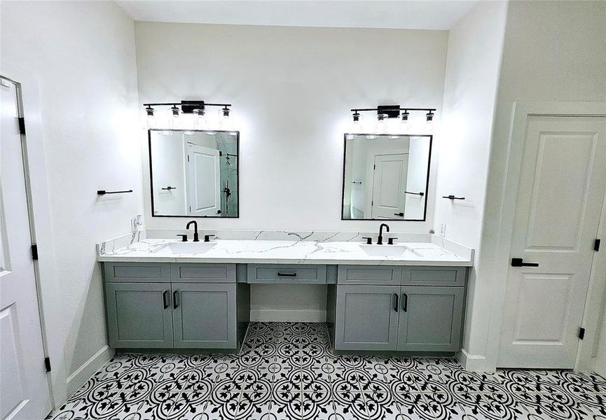 Primary bath dual vanities, enough space for elbow room. Door leads to linen closet.