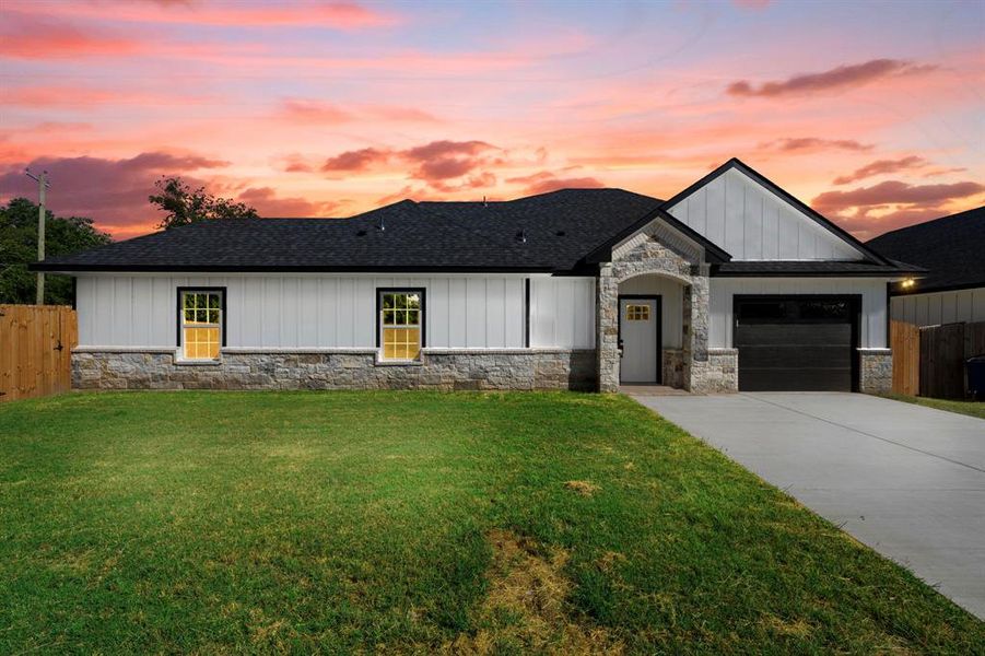 View of front of home featuring stone siding, driveway, a shingled roof, and an attached garage View of front of home featuring stone siding, driveway, a shingled roof, and an attached garage