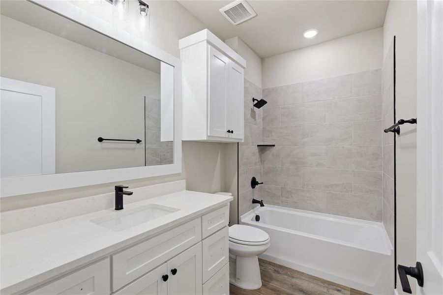Contemporary bathroom featuring a white vanity with quartz countertop, undermount sink, and matte black faucet Contemporary bathroom featuring a white vanity with quartz countertop, undermount sink, and matte black faucet
