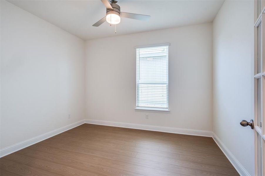 Unfurnished room featuring dark wood-style floors and ceiling fan