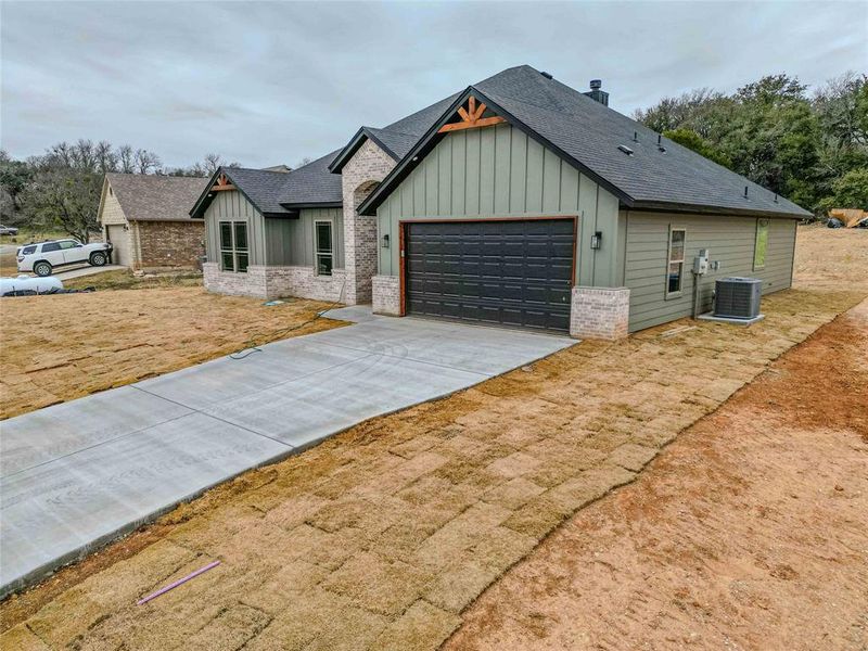 View of front of property with a garage and central air condition unit