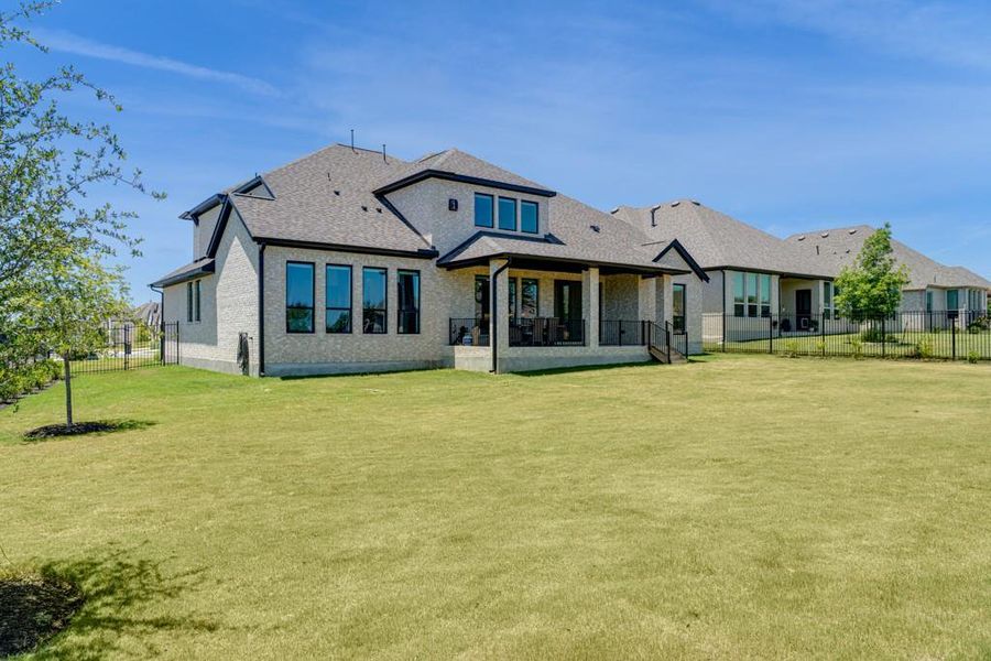 Generous green spaces surround this elegant home, complete with an inviting covered patio for outdoor enjoyment. Generous green spaces surround this elegant home, complete with an inviting covered patio for outdoor enjoyment.