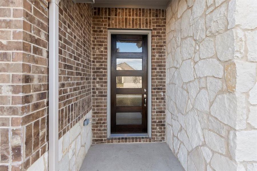 Doorway to property with brick siding