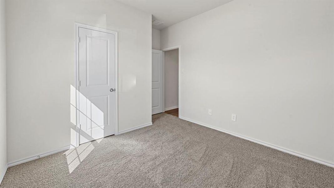 Spacious room featuring light gray carpeting and white walls