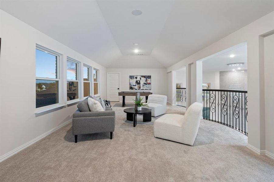 Carpeted living room featuring lofted ceiling