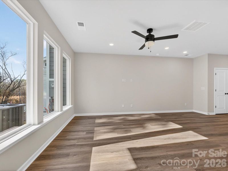 Living room area features 3 large picture windows that bathe the room in natural light & have views of the wooded backyard.