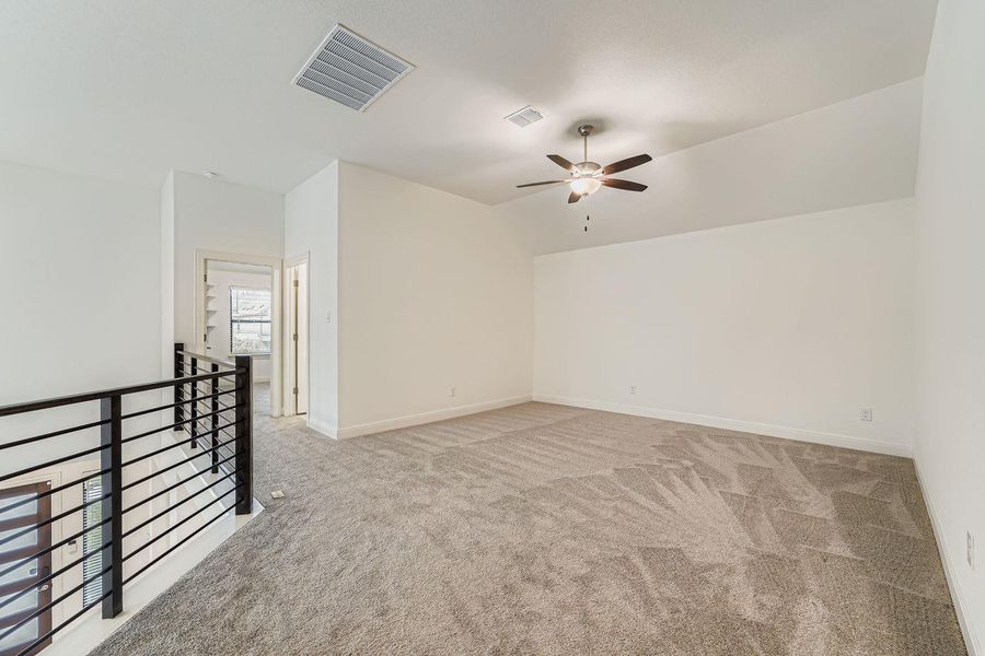 Empty room with light carpet, lofted ceiling, and ceiling fan Empty room with light carpet, lofted ceiling, and ceiling fan