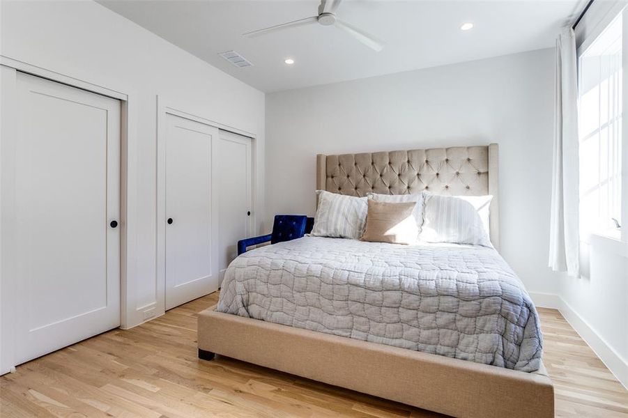 Bedroom with multiple closets, light wood-type flooring, recessed lighting, and a ceiling fan Bedroom with multiple closets, light wood-type flooring, recessed lighting, and a ceiling fan