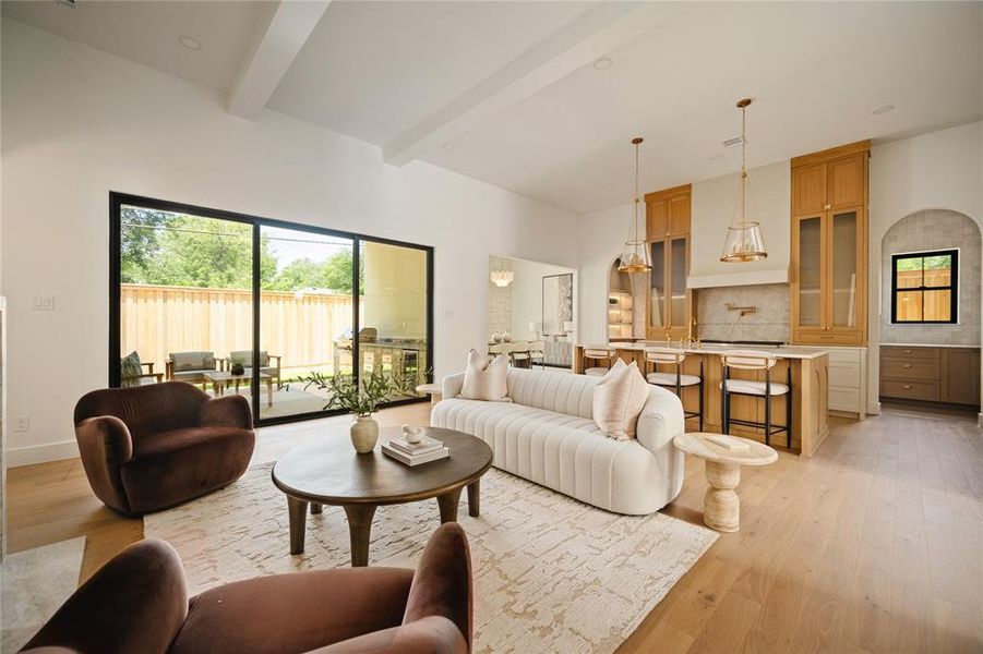 Living area with beamed ceiling and light wood finished floors