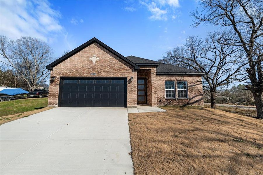 View of front of house with a garage and a front lawn