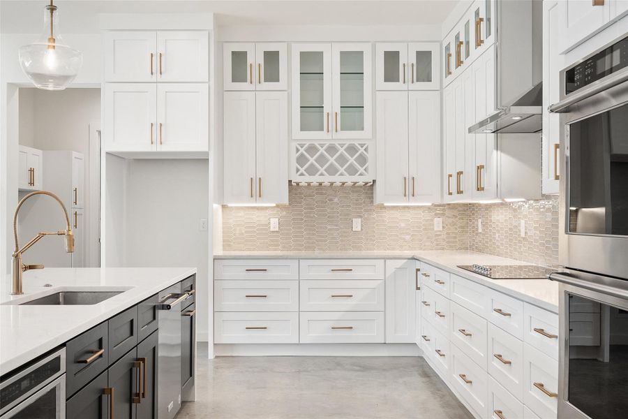 Kitchen with pendant lighting, stainless steel double oven, tasteful backsplash, and white cabinets Kitchen with pendant lighting, stainless steel double oven, tasteful backsplash, and white cabinets