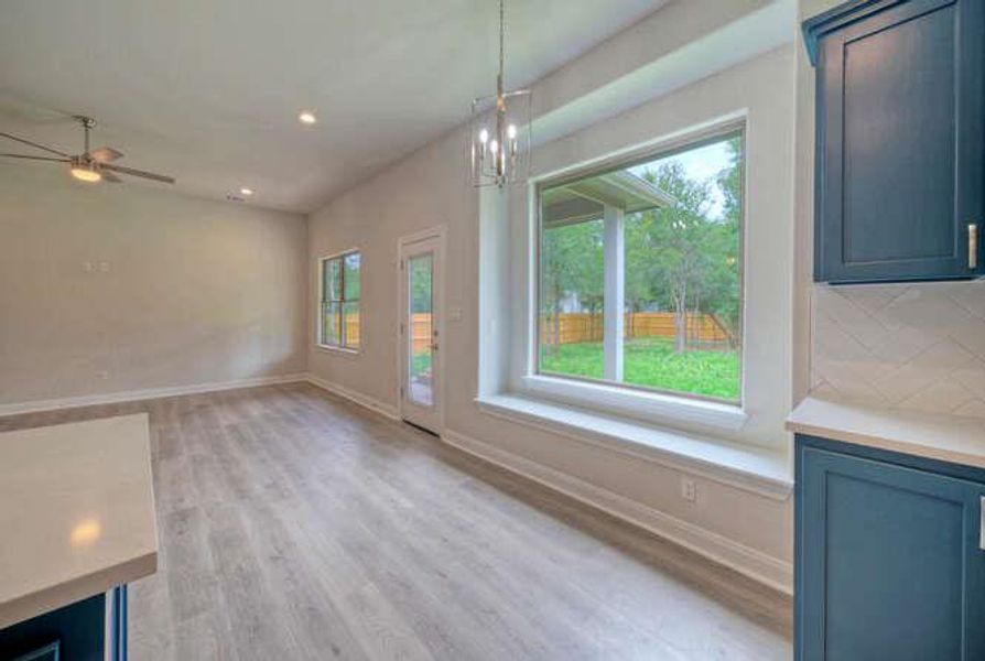 Unfurnished dining area with plenty of natural light, light wood-style floors, a chandelier, recessed lighting, and ceiling fan