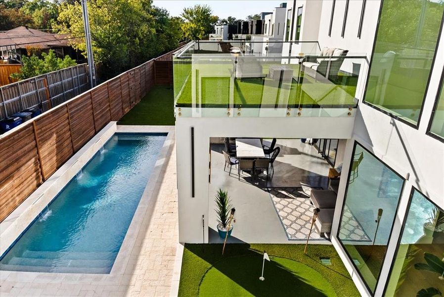 View of pool with a patio below and Balcony above