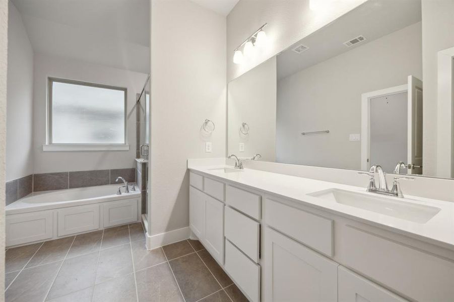 Bathroom with tile patterned flooring, a tub to relax in, and vanity