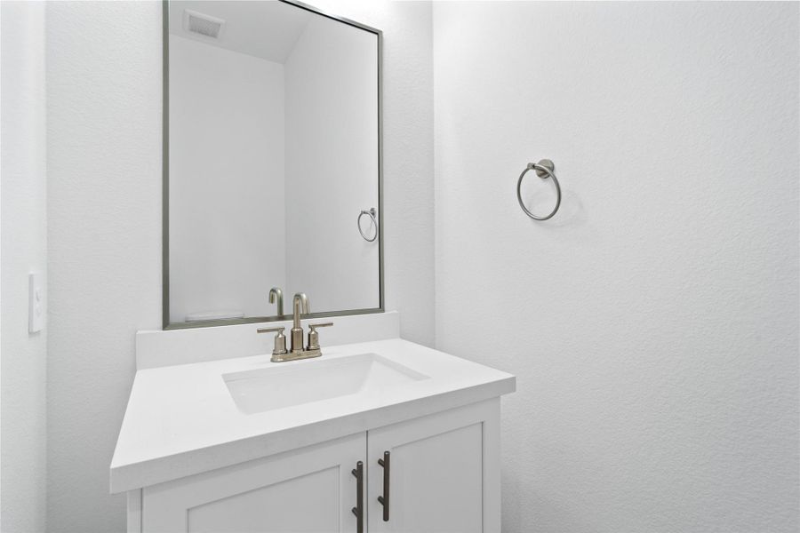 The powder bath features a stylish vanity and a clean, modern design. The powder bath features a stylish vanity and a clean, modern design.