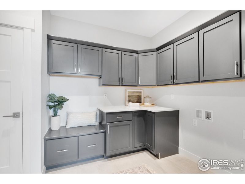 A convenient "drop-zone" mudroom/butler pantry/laundry room right between the garage and kitchen, with plenty of storage & a closet