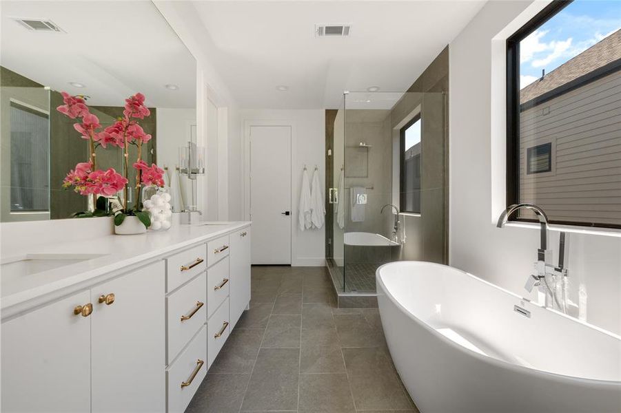 Bathroom featuring vanity, tile floors, and a bathtub