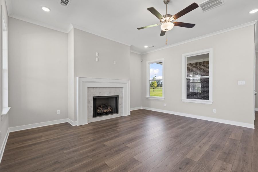 Unfurnished living room featuring ornamental molding, recessed lighting, Revwood finished floors, a gas fireplace, and ceiling fan