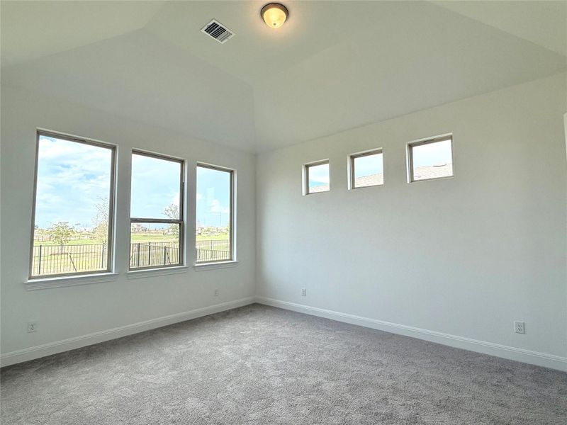 Unfurnished room with carpet flooring and lofted ceiling Unfurnished room with carpet flooring and lofted ceiling