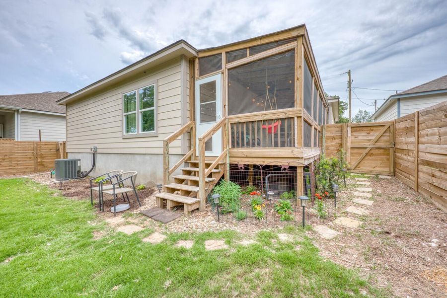 Screened porch with natural wood decking, steps, and railing