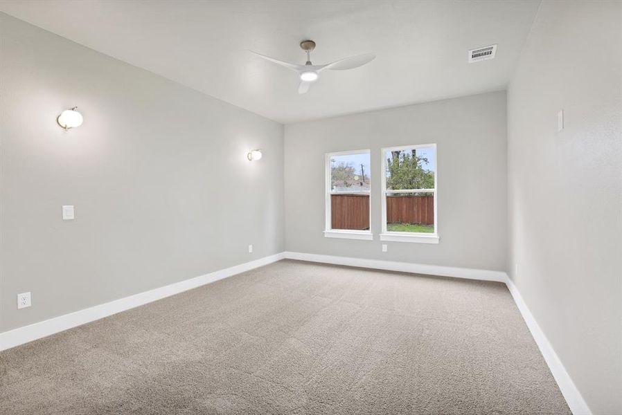 Carpeted empty room featuring ceiling fan