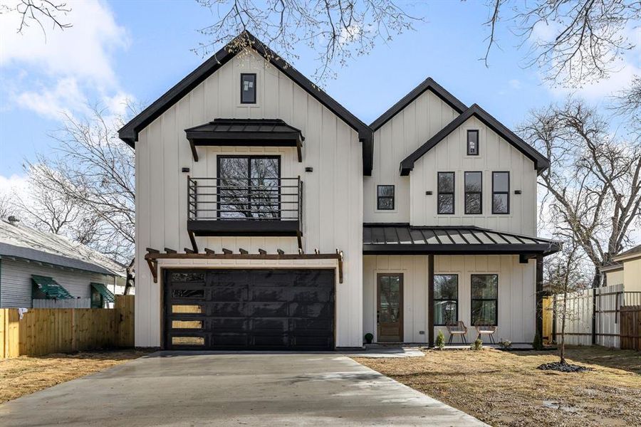 Modern inspired farmhouse featuring board and batten siding and a standing seam roof