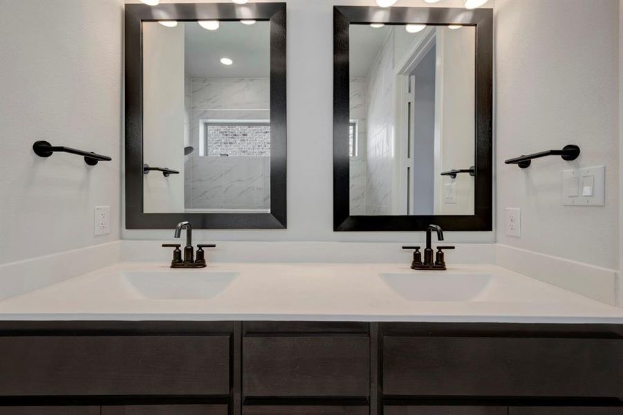 Bathroom with double vanity and a marble finish shower