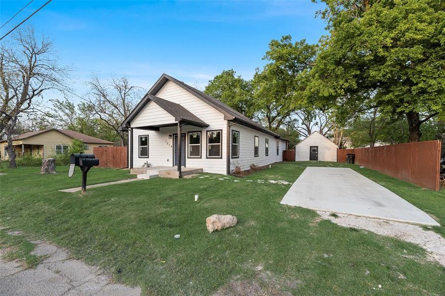 Bungalow-style house with an outdoor structure and a patio area