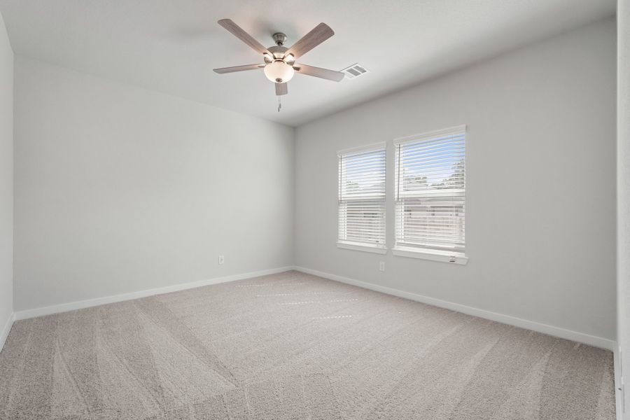 A ceiling fan in a room. A ceiling fan in a room.