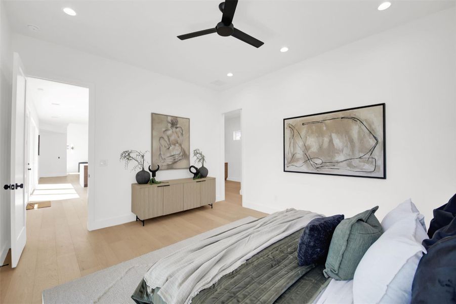 Primary bedroom featuring light wood finished floors, ceiling fan, and recessed lighting