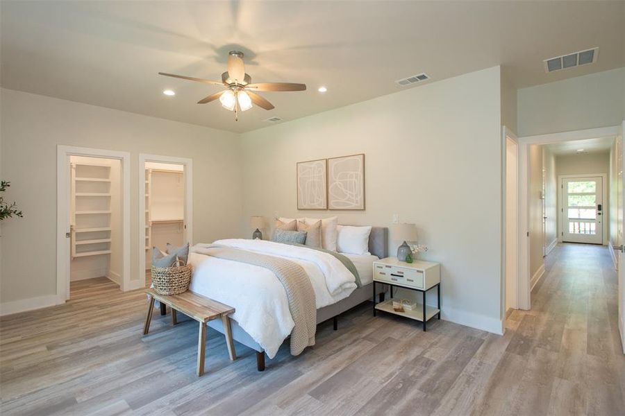 Bedroom featuring light hardwood / wood-style flooring, ceiling fan, a walk in closet, and a closet