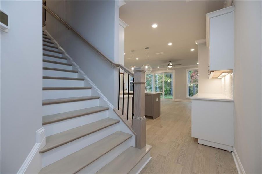 Staircase featuring hardwood / wood-style flooring and ceiling fan