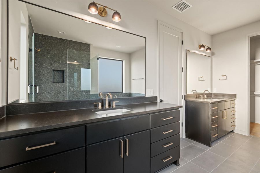 Dual vanities and a spacious walk-in shower elevate this private primary bathroom.
