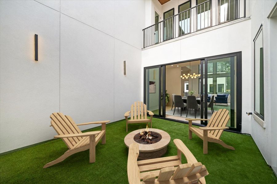 The turfed and drained central courtyard can be entered  via the front gate but also from the Pella sliding door in the formal Dining Room, as well as the French doors from both the Entry and the downstairs Study. When the weather is right, all these can open up for an extra entertaining area flow in addition to the covered back porch. (virt. staged)