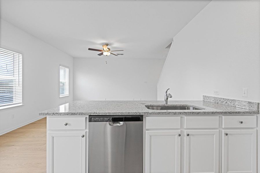 Granite countertops and clean white cabinetry highlight this functional open-concept layout.