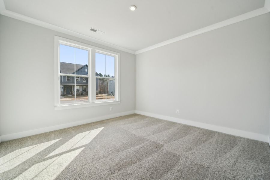 A room with a window and a rug.