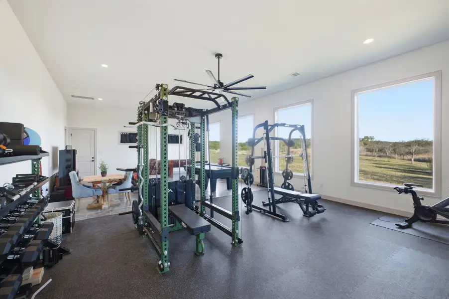 This versatile room features large windows and a ceiling fan, providing a bright and airy environment