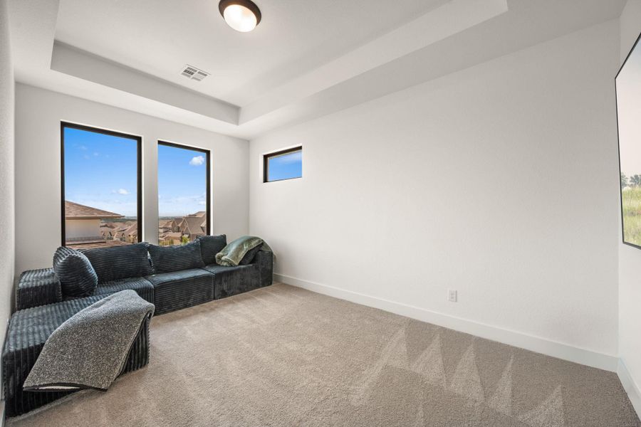 Natural light streams into this versatile room, offering a cozy corner and broad views through vertical windows. Natural light streams into this versatile room, offering a cozy corner and broad views through vertical windows.