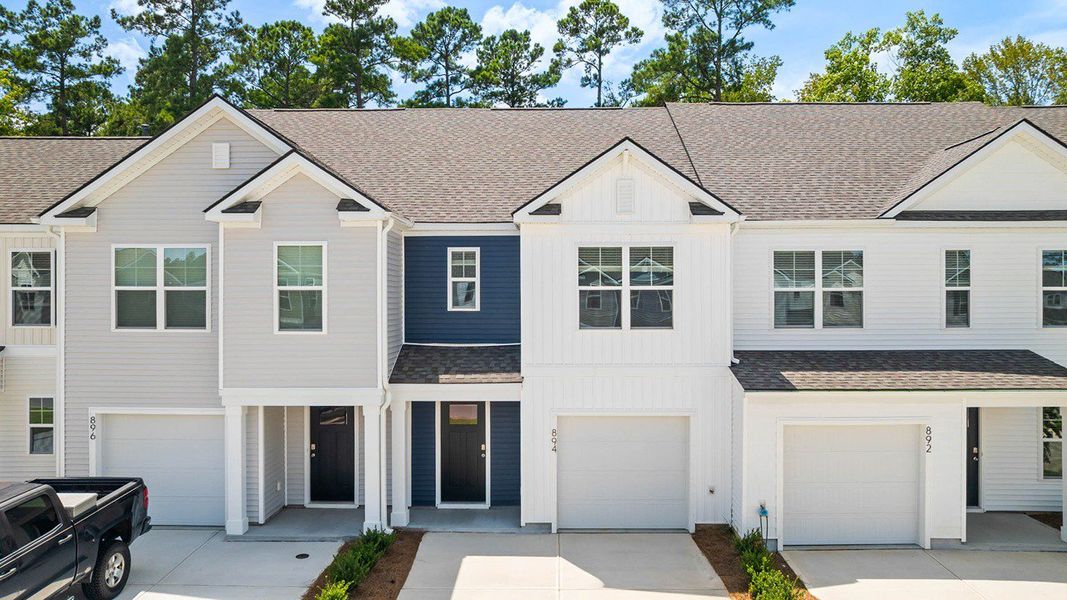Front exterior of a new home in Pine Hills Townhomes at Cane Bay, Summerville, SC, highlighting curb appeal (Image 1). Front exterior of a new home in Pine Hills Townhomes at Cane Bay, Summerville, SC, highlighting curb appeal (Image 1).