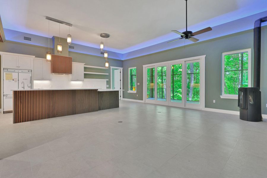 Modern kitchen and living combo with designer lighting, sliding patio door leads to screened in porch, and sleek finishes