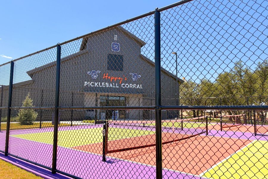 Fenced pickleball courts provide an active outdoor recreation space adjacent to the main building.
