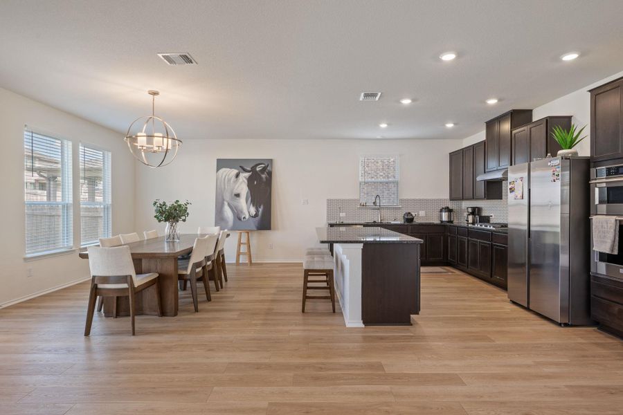 Kitchen featuring dark wood finish cabinets, a kitchen bar, stainless steel appliances, and a center island