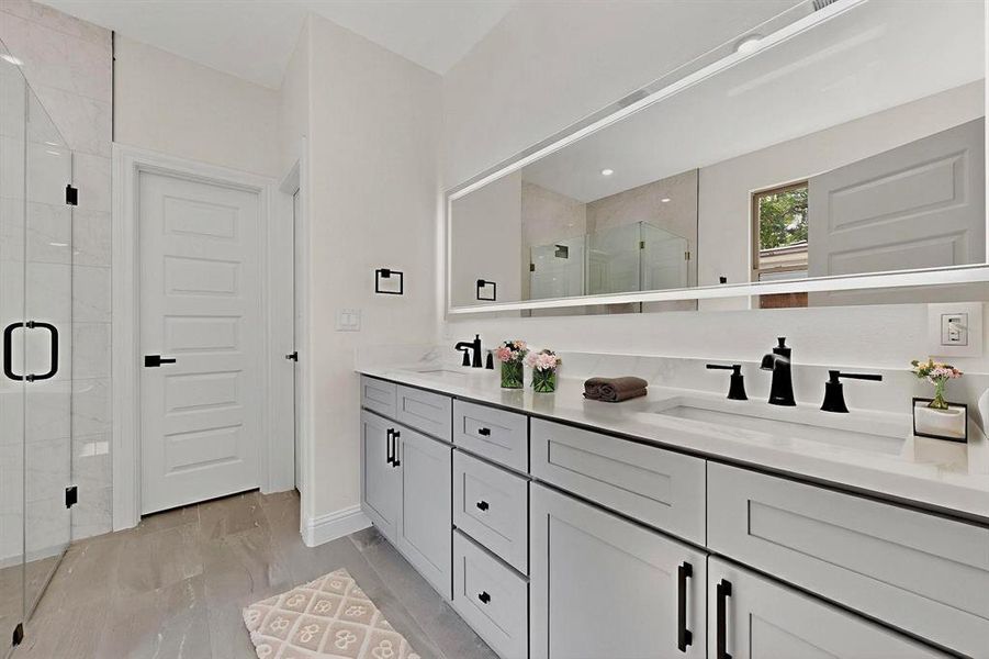 Full bath featuring a stall shower and double vanity Full bath featuring a stall shower and double vanity