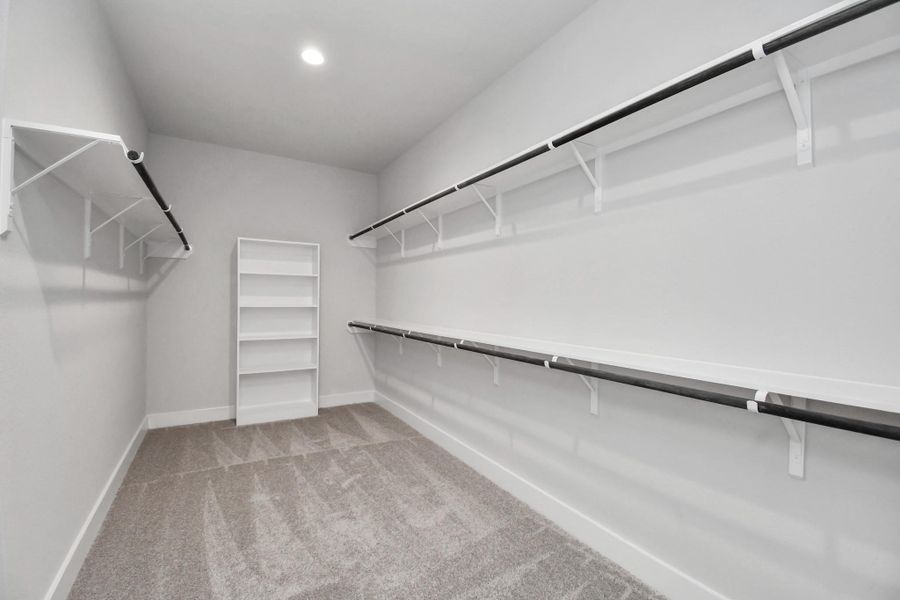 Walk-in closet that epitomizes luxury and practicality. This generously sized space features built-in shelving, offering abundant room for impeccable organization. High ceilings and recessed lighting create a bright and welcoming ambiance.