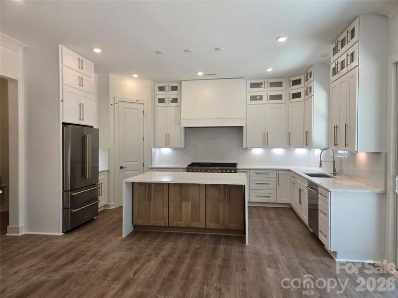 Stunning chef's kitchen featuring high-end quartz countertops with a matching waterfall backsplash. This gourmet space includes a large walk-in pantry, premium Z-Line 48-inch dual-fuel gas range, stainless steel appliances, a full-size refrigerator, and a convenient wine/beverage cooler. Stunning chef's kitchen featuring high-end quartz countertops with a matching waterfall backsplash. This gourmet space includes a large walk-in pantry, premium Z-Line 48-inch dual-fuel gas range, stainless steel appliances, a full-size refrigerator, and a convenient wine/beverage cooler.